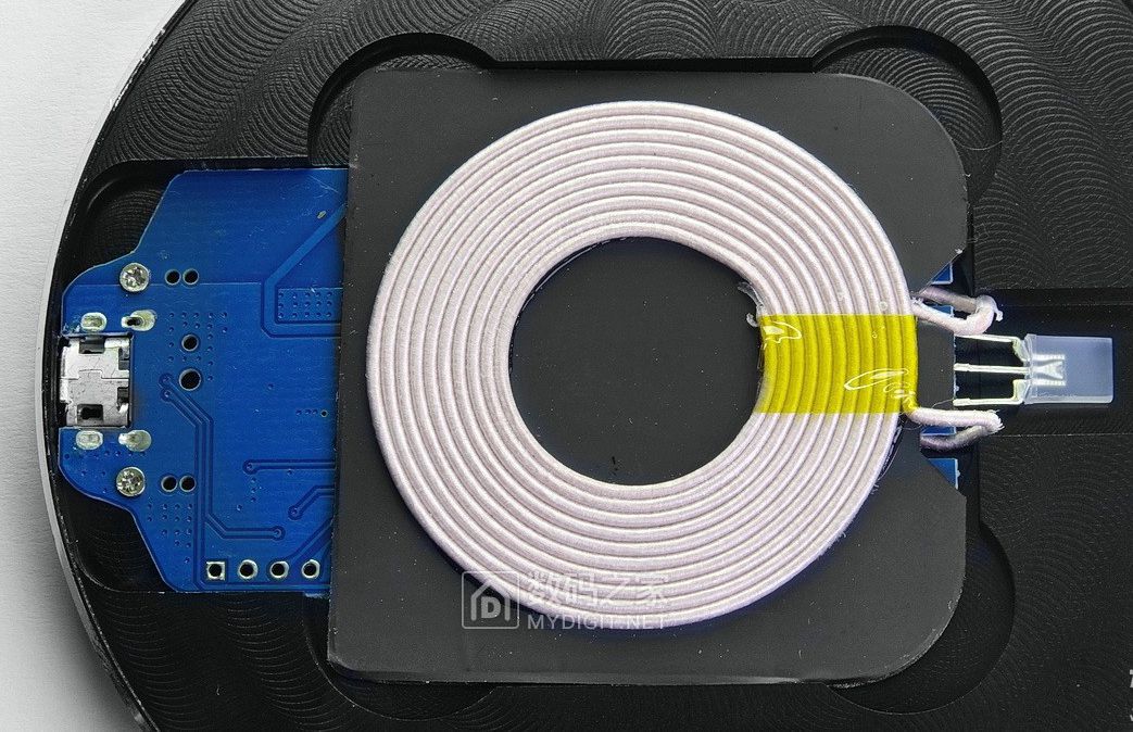位于中心的无线充电线圈，下面是一块长方形的蓝色PCB，中间垫有隔磁板，左面是一只双色LED指示灯，右侧是Mi ...